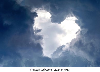 Heart shape appears in the cloudy dramatic sky. Heart frame shaped clouds on sky background.