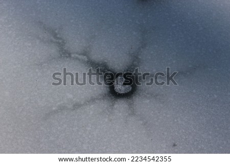 Heart shape in broken ice on frozen pond