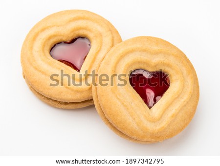 Heart shape cookie. Hearts on Valentines day. Red jam or strawberry jelly inside biscuit cookie. Homemade baking. Happy Saint Valentine's Day February 14. Sweet bakery. Top view on white background.
