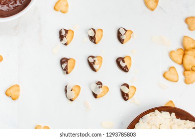 Heart Shape Cookies For Valentines Day Covered With Chocolate And Almonds On Light Marble Background. Top View, Flat Lay.