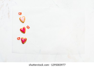 Heart Shape Cookies For Valentines Day And LIKE Symbols On White Paper And Light Marble Background With Blank Space For Text. Top View, Flat Lay.