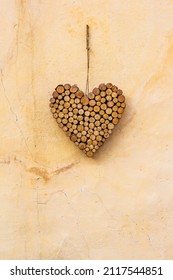 Heart Shape Decoration Made Of Small Wood Sticks Hanging On The Yellow Wall As Welcome Sigh