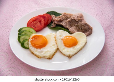 Heart Shape Fired Eggs Witch Pork Steak And Vegetables On White Plate