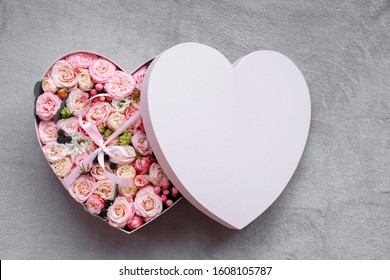 Heart shape gift box and bouquet. fresh flowers a gift in the shape of a heart. roses in a box heart close-up with a blurred background on a white  table. pink roses, yellow roses - Powered by Shutterstock