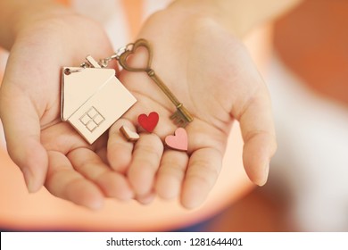 Heart Shape Home Key With House Keyring And Mini Heart Figure On Kid's Hand To Giving, Sweet Valentine Home Present Giving Concept, Soft Color Tone, Copy Space, Copy Space