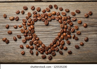 Heart shape made from coffee beans on wooden surface. - Powered by Shutterstock