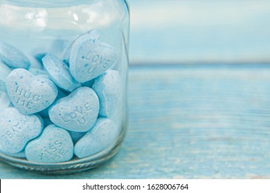 Heart Shape Message Letter Candy In Glass Jar On Blue Wood Background. Valentines Day Concept.	
