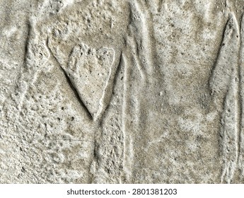 Heart shape pattern engraved on a rough gray concrete wall texture background.