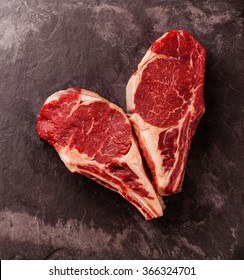 Heart Shape Raw Fresh Meat Ribeye Steak On Bone On Stone Slate Background