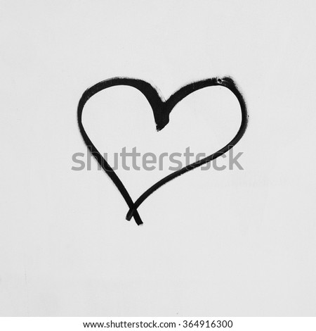 Heart shape sketched on a white wall in black ink