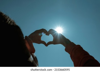 Heart Shape, Young Man Trying To Get The Sun Into His Hands, A Blue Sky And A Bright Sun, Ecosystem And Oxygen