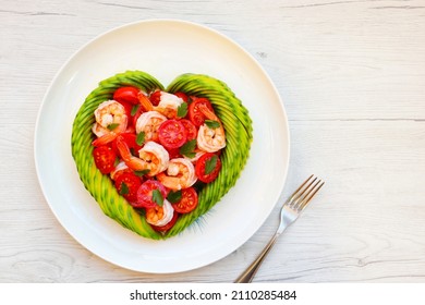 Heart shaped avocado with roasted shrimps,cherry tomatoes and parleys on plate with white wood background.Love healthy food concept for Valentine's day.Top view.Copy space

 - Shutterstock ID 2110285484
