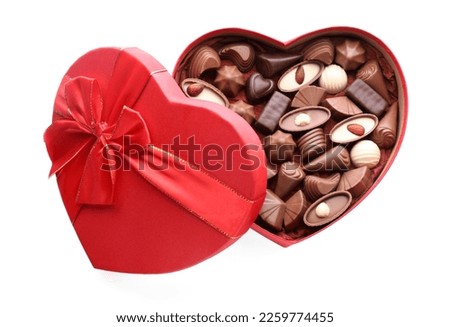 Heart shaped box with delicious chocolate candies isolated on white, top view