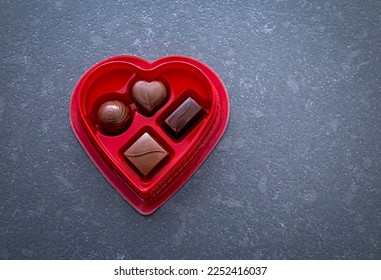 Heart Shaped Candy Box  filled with chocolate pieces shot on a gray stone background - Shutterstock ID 2252416037