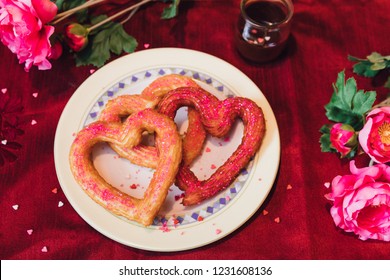 Heart Shaped Churros Food With Sprinkles On Red Table With Flowers For Valentines