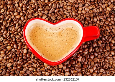 Heart shaped coffee mug dived in coffeen beans, Valentines day. Vertical, with copy space. - Powered by Shutterstock