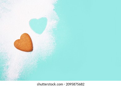 Heart Shaped Cookies And Flour On A Blue Background. View From Above. Making Baked Goods For Valentine's Day