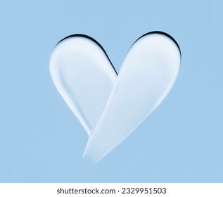 Heart shaped cosmetic smear of cream on a blue background