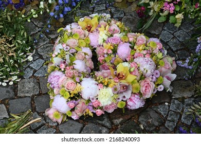 Heart shaped grave arrangement with pink, yellow and white flowers - Shutterstock ID 2168240093