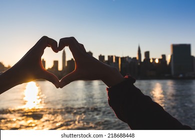 Heart Shaped Hands at Sunset, New York Skyline on Background