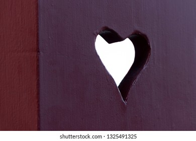 heart shaped hole cut in the red board