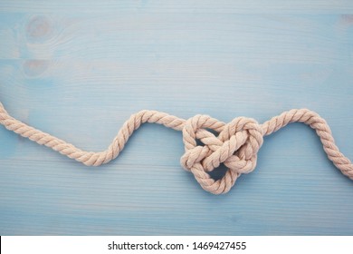 Heart shaped knot on blue wooden background