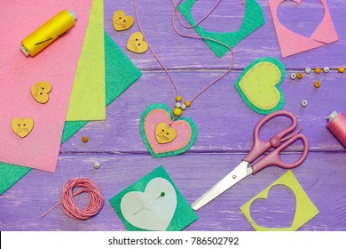 Heart Shaped Pendant Necklace. Valentines Day Necklace Made Of Colored Felt, Beads And A Wooden Button. Craft Supplies On A Wooden Background. Gift For Mother. Kids Arts And Crafts Activity