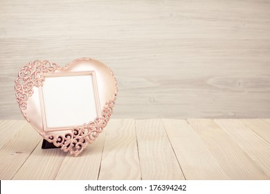 Heart Shaped Photo Frame On Wooden Table