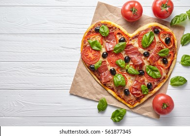 Heart Shaped Pizza Love Concept Valentine's Day Design Symbol Romantic Restaurant Dinner Italian Food. Prosciutto, Olives, Tomatoes, Basil And Mozzarella Cheese Meal Served On White Table Background