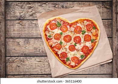 Heart Shaped Pizza Margherita With Tomatoes And Mozzarella For Valentines Day On Vintage Wooden Background. Food Concept Of Romantic Love.