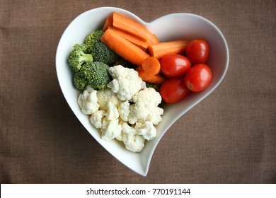 Heart Shaped Plate With Assorted Fresh Vegetables, Top View. Raw Vegetables (tomatoes, Cauliflowers, Broccoli, Carrots, Spinach) Ingredients For Snack, Salad Or Soup.