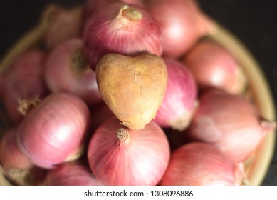 Heart Shaped Potato Among Onions.  Express You Love In A Unique Way And Leave A Lasting Impression.  