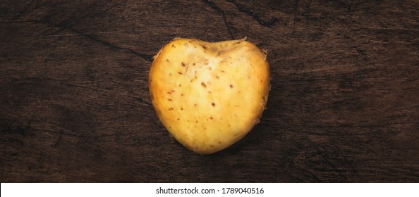 Heart Shaped Potatoes Ion Wooden Background, Top View. Respect For Agriculture Concept