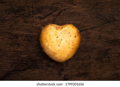 Heart Shaped Potatoes Ion Wooden Background, Top View. Respect For Agriculture Concept