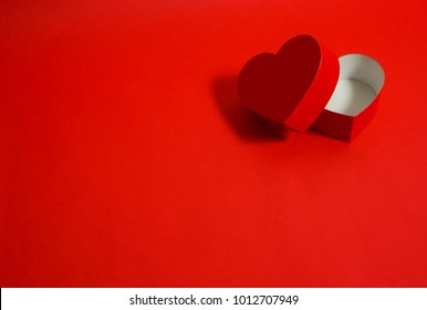 Heart shaped present. red background