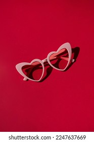 Heart shaped sunglasses on the red background. Valentine's day concept composition - Shutterstock ID 2247637669