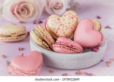 Heart shaped sweet macarons and roses in pastel colors on a pink base. A delicious dessert or gift for Valentine's Day or Mother's Day. - Powered by Shutterstock