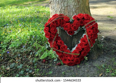 Heart Shaped Sympathy Flowers  Or Funeral Flowers Near A Tree, Big Red Roses