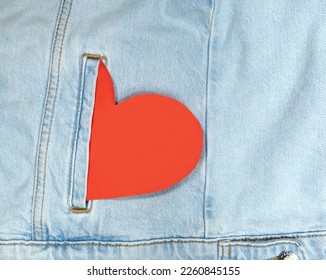 heart shaped and torn on red jeans fabric with white copy space. love
