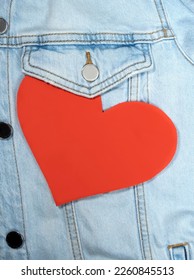 heart shaped and torn on red jeans fabric with white copy space. love