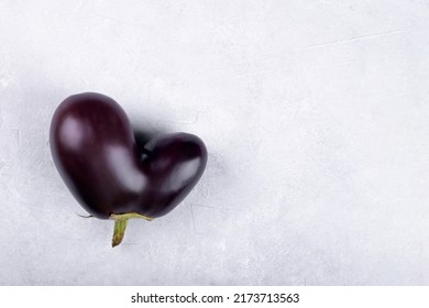 Heart Shaped Ugly Eggplant Isolated On Concrete Grey Background, Funny Aubergine Vegetables For A Healthy Diet With Copy Space, Funny Unnormal Vegetable Concept