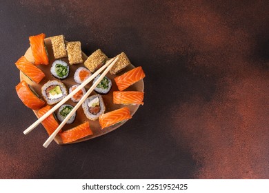 Heart shaped Valentine day sushi set. Classic sushi rolls, philadelphia, maki set for two, with two pairs of chopsticks for Valentine's dating dinner, with rose flowers bouquet on dark background - Shutterstock ID 2251952425