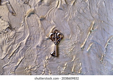 Heart Shaped Vintage Key On Abstract  Background Coating Putty With Pearlescent Paint Rough Wall Surface With Uneven Coating With Silver Gold Paint. Retro Noise Grain Effect