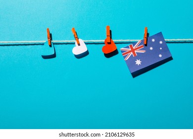 Heart Shapes And Australia Flag Hanging On Clothesline With Copy Space Over Blue Background. Patriotism, Symbol And Identity.