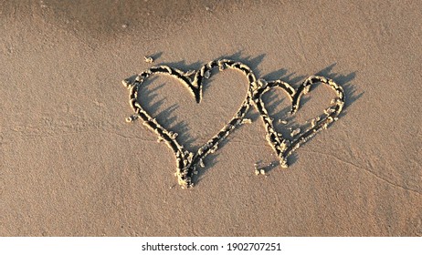 Heart Shapes Being Drawn on Sandy Beach and Wiped Out by Sea Wave at Sunset