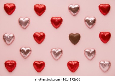 Heart shapes pattern on a pink background viewed from above. Top view of a chocolate candy hearts