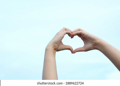 heart symbol from hands on sky background