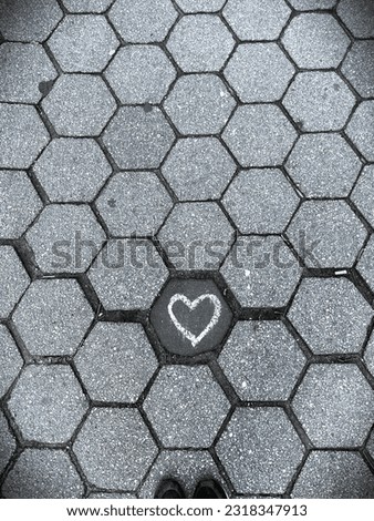 Heart symbol icon in pink chalk on a gray sidewalk in new york city