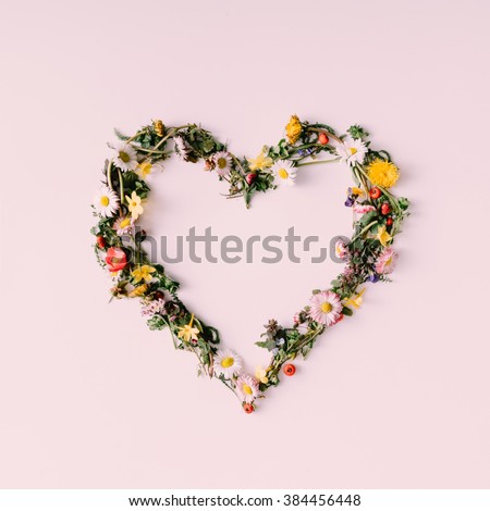 Heart symbol made of flovers and leaves on white background.