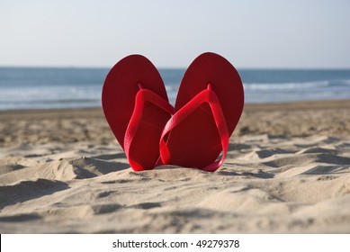 Heart Symbol Made Of Red Flip Flops On The Beach